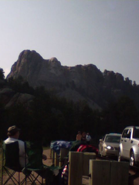 2007 Dodge Caliber - A view of Mount Rushmore National Memorial with several vehicles parked nearby, suggesting a tourist destination.