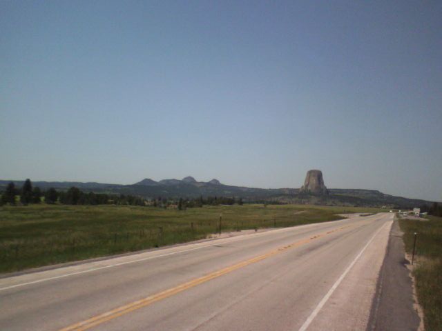 Highway leading towards Devils Tower under a clear blue sky
