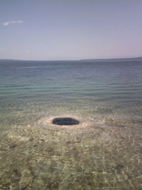 2007 Dodge Caliber - A natural opening in the water creates a dark circle, with the seabed visible through the clear water.