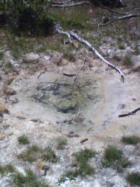 2007 Dodge Caliber - A natural hot spring with clear water, surrounded by dry ground and sparse vegetation.