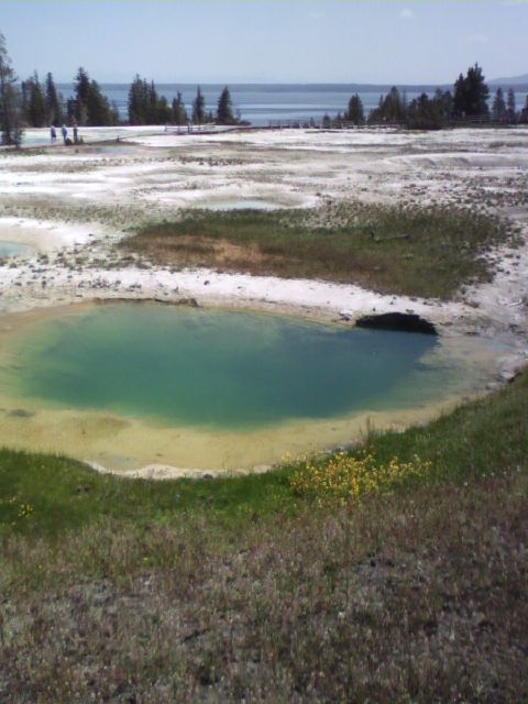 2007 Dodge Caliber - A vibrant turquoise pool sits in a barren landscape with a distant lake and trees under a clear sky.