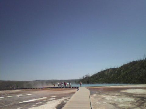 2007 Dodge Caliber - A boardwalk leads through a colorful, steaming geothermal landscape under a clear blue sky.