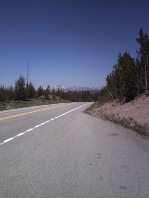 2007 Dodge Caliber - A scenic view of a highway winding through a forested area, with mountains visible in the distance.