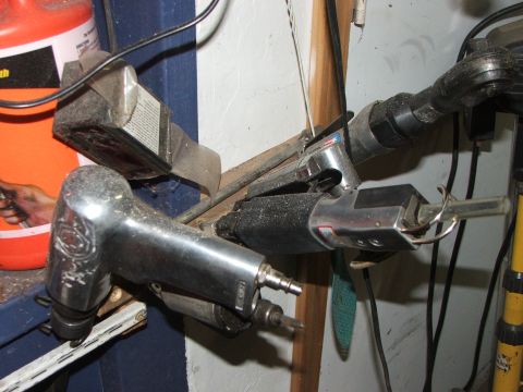 1965 Ford Mustang - Various pneumatic tools are organized on a shelf in a workshop setting, with a large orange container visible in the background.