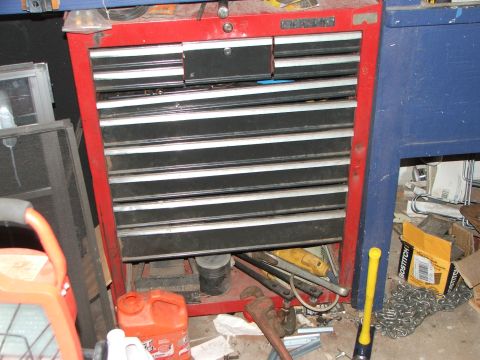 1965 Ford Mustang - A red tool chest is filled with drawers and surrounded by various tools and garage items.