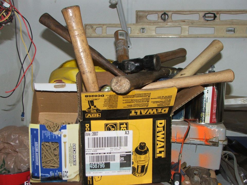 Box of hammers and tools, including a DeWalt box with a label that says store 3907 and item number 458796