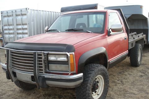 1994 GMC Sierra 3500 - This red pickup truck features a flatbed and appears to be from the mid-1990s.