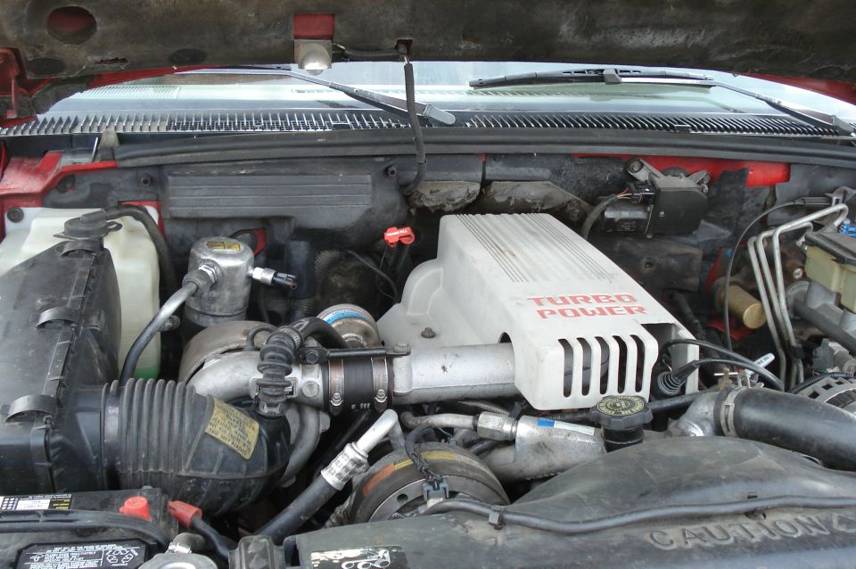 Engine bay with Turbo Power cover and red paint visible