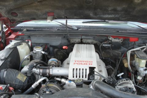 1994 GMC Sierra 3500 - The engine bay of a vehicle, a prominent 'Turbo Power' cover and various engine components.