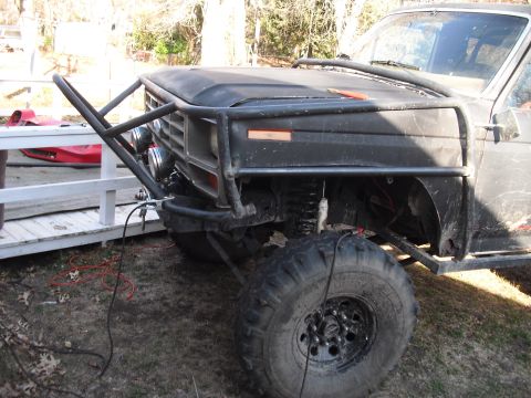 1986 Ford Bronco - Front view of a heavily modified SUV, possibly a Ford Bronco, with a custom brush guard and off-road tires.