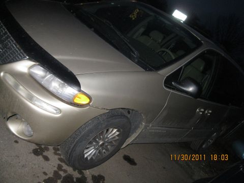 1984 Chevrolet C/K Pickup - A tan minivan is parked on a wet surface at night. The date stamp reads 11/30/2011.