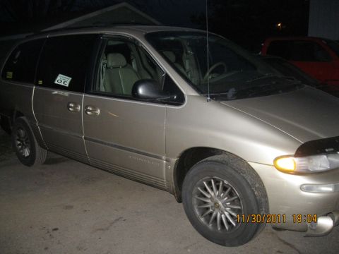 1984 Chevrolet C/K Pickup - A tan minivan is parked outside, showing its front and side profile. A sticker is visible on the driver's door.