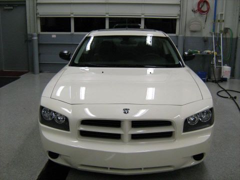 1988 Mercury Grand Marquis - A white Dodge Charger is shown from the front in a garage setting, with its distinctive grille and headlights visible.