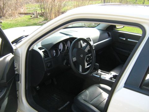 1988 Mercury Grand Marquis - The interior of a white Dodge Charger shows black leather seats and a modern dashboard.