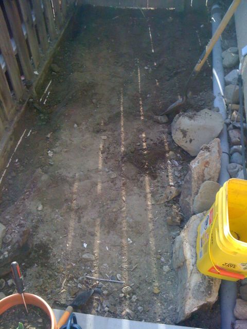 1968 Ford Mustang - A dirt area is being worked on with gardening tools and a yellow bucket nearby.