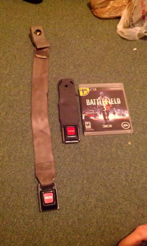 1992 Ford Ranger - A seatbelt assembly and a copy of Battlefield 3 are placed on a carpeted floor.
