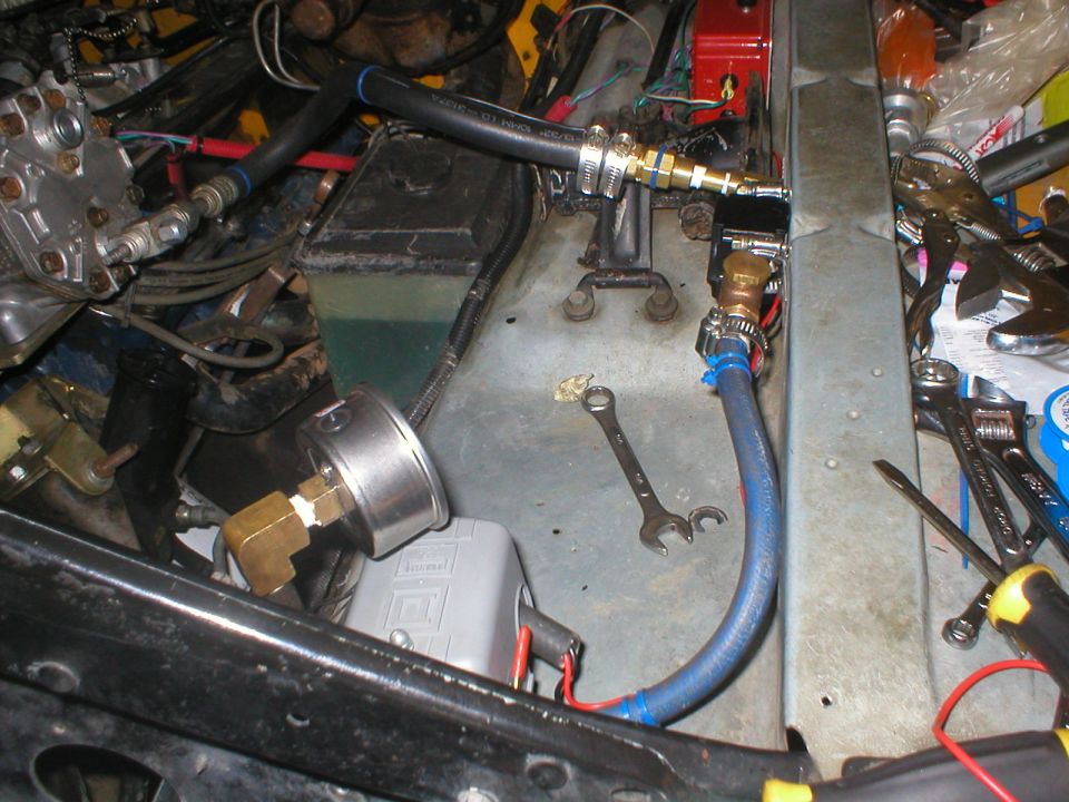 Engine bay plumbing with pressure gauge and tools