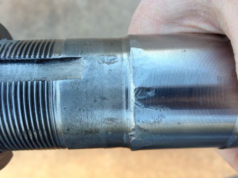 1996 Ford Bronco - A close-up view of a damaged metal shaft with visible splines and machined grooves.