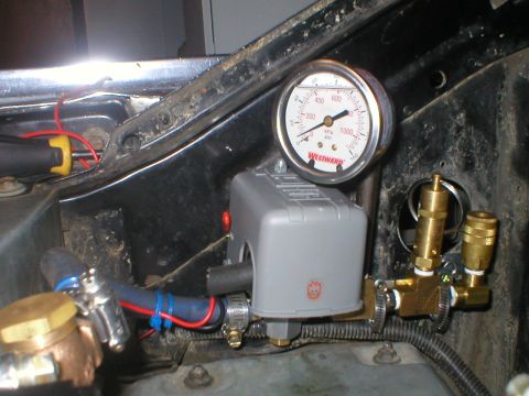1978 Ford Bronco - Close-up of an air compressor pressure switch and gauge assembly with associated plumbing.
