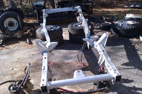 1989 Jeep Wrangler - Disassembled Jeep Wrangler frame and components laid out outdoors.