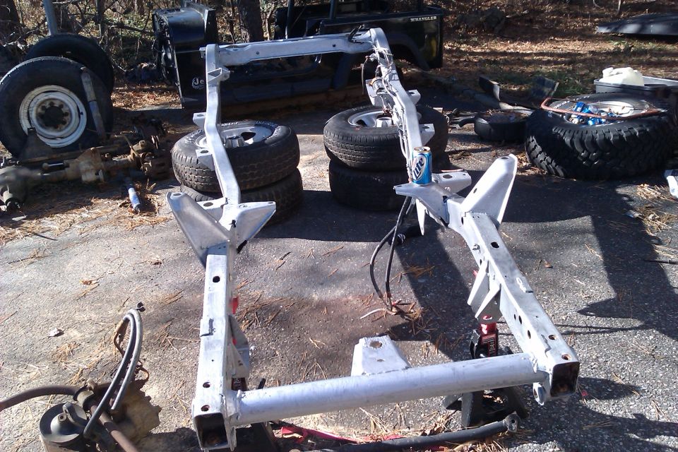 Jeep Wrangler frame disassembled with tires and other parts scattered around