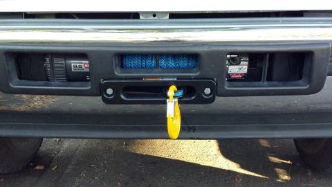1996 Ford Bronco - Close-up of a vehicle's front bumper, equipped with two winches and a tow shackle.