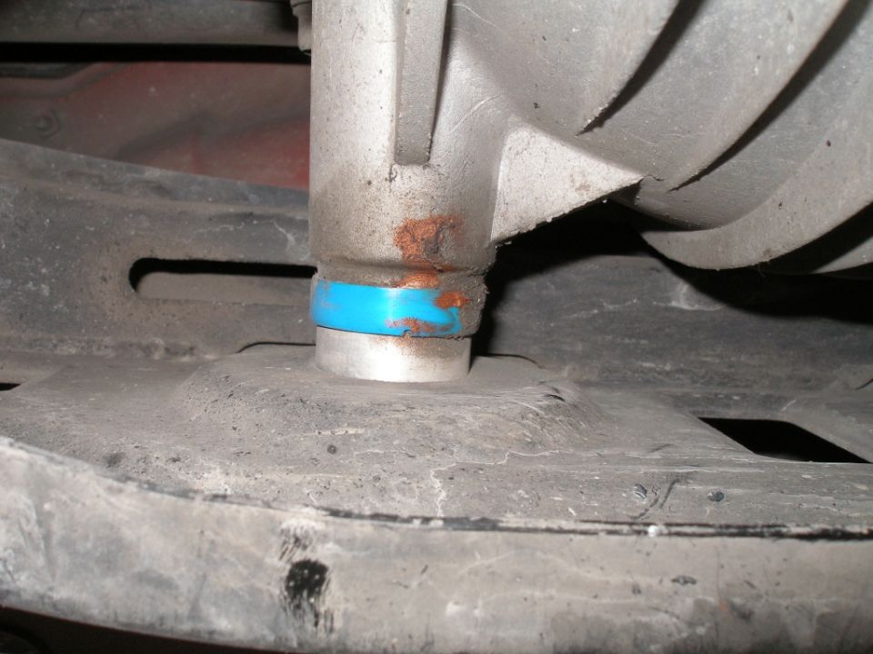 Close-up of a suspension part with a blue bushing and some rust