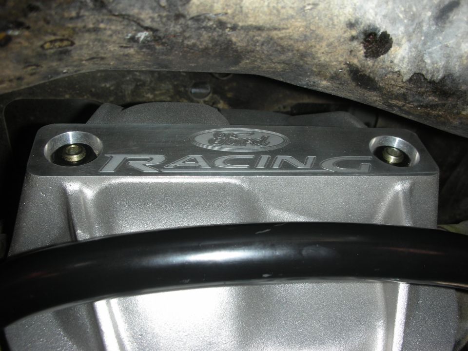 Silver Ford Racing engine cover with bolts and black bar
