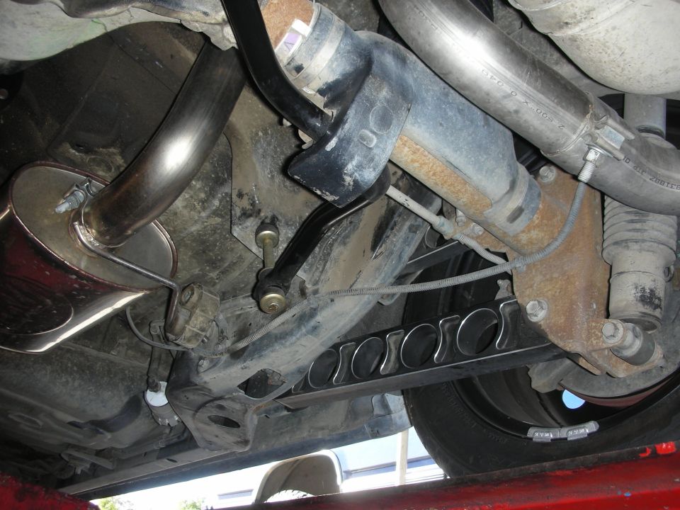 Rear suspension and exhaust system with custom trailing arms