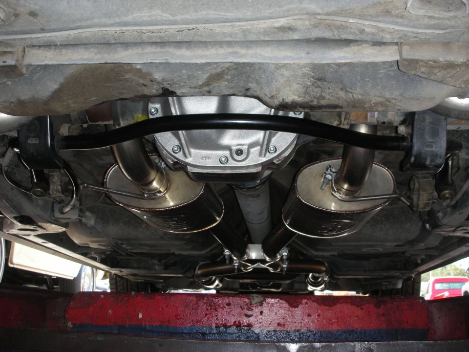 Underside view of a rear differential with dual exhaust mufflers and pipes