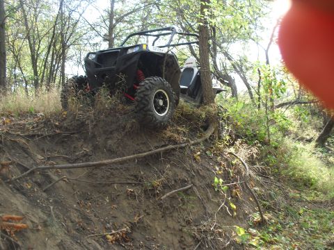 1986 Ford Bronco - An all-terrain vehicle navigates a steep, wooded incline.
