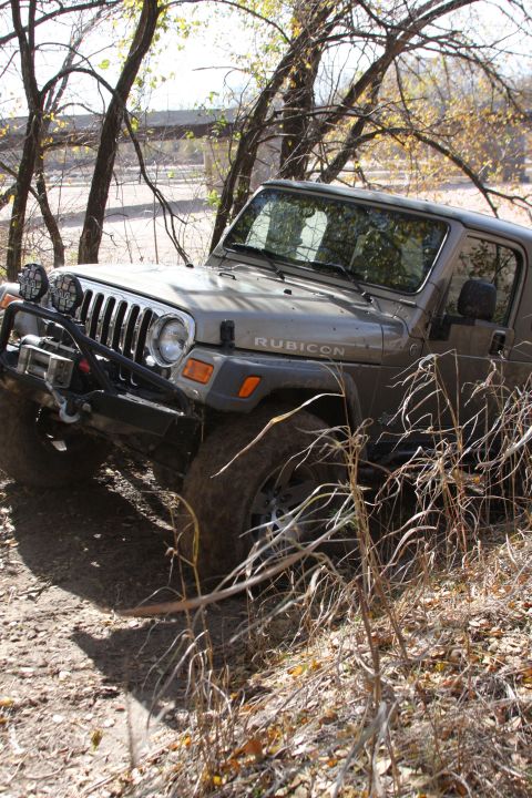 2005 Jeep Wrangler - A 2005 Jeep Wrangler Rubicon navigates an off-road path surrounded by autumn foliage.
