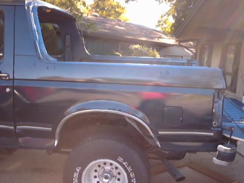 1990 Ford Bronco - The rear quarter panel and tailgate of a Ford Bronco are shown in this side profile shot.