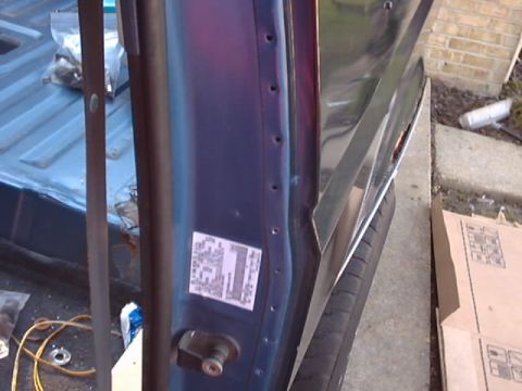 1990 Ford Bronco - Close-up of a vehicle's interior door jamb and truck bed area, with a sticker on the door.