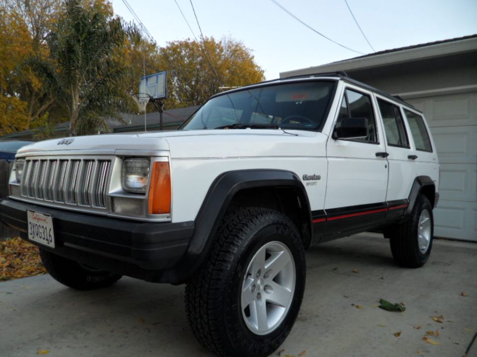 White Jeep Cherokee XJ SUV, front 3/4 view, parked in driveway
