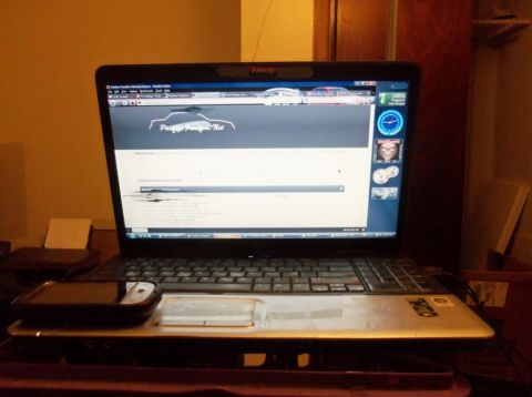 2000 Mercury Grand Marquis - A laptop displays a car enthusiast website with a silhouette of a vehicle on its screen.
