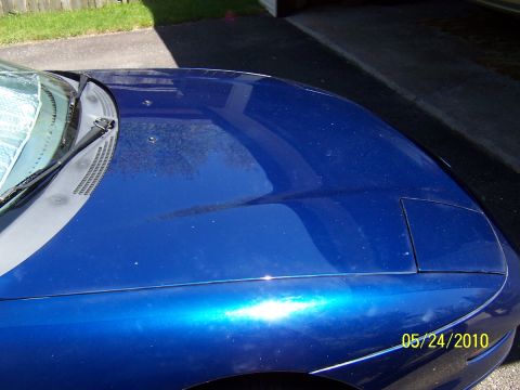 1993 Ford Probe - Close-up of a blue car's hood and fender, showing a pop-up headlight cover.