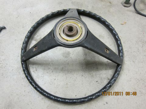 1969 Ford Mustang - A black steering wheel with a three-spoke design and a textured rim is shown, likely a replacement part.