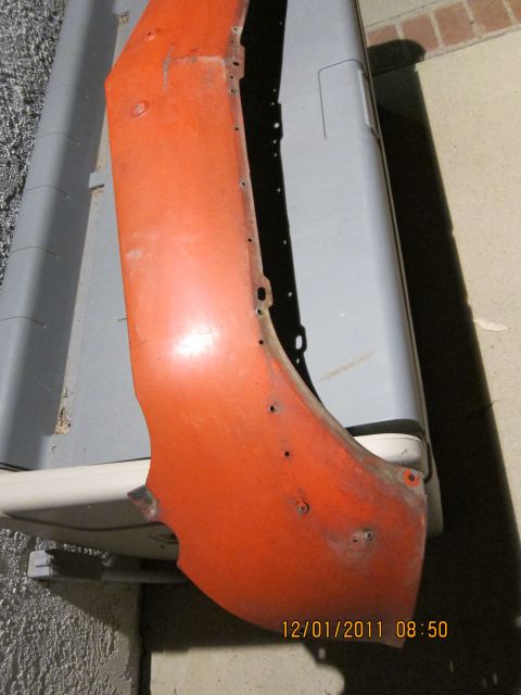 1969 Ford Mustang - An orange fender part is shown, with visible mounting holes and signs of rust.