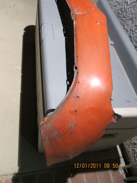 1969 Ford Mustang - An orange fender part is shown, likely for an older vehicle, with visible mounting holes and signs of wear.
