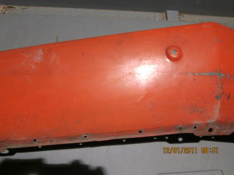 1969 Ford Mustang - Close-up of an orange car fender showing signs of wear and tear.