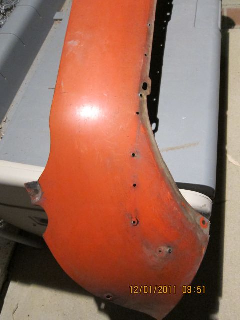 1969 Ford Mustang - This orange fender part shows signs of wear and has multiple mounting holes visible.