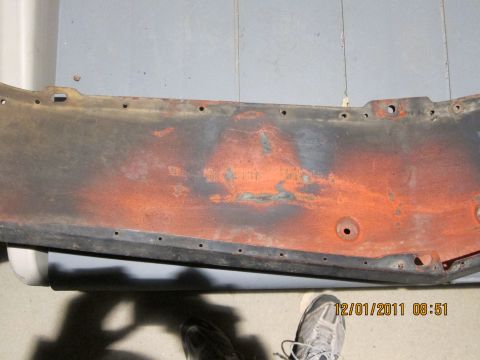 1969 Ford Mustang - A close-up view of a heavily rusted metal panel, likely a car part, showing signs of wear and tear.