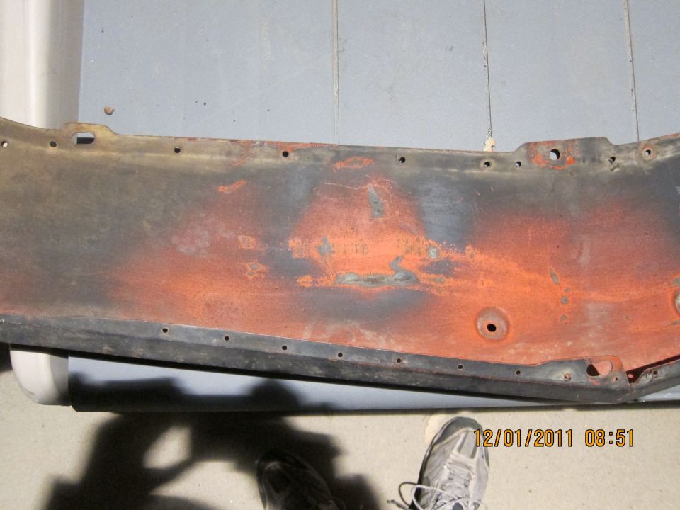 Rusted metal panel with orange undercoat, black trim, and mounting holes