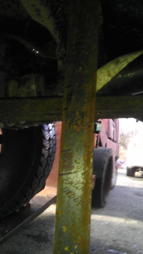 1989 Ford Bronco - A close-up view of a green suspension component with handwritten markings that include 'EM TLL D2006'.