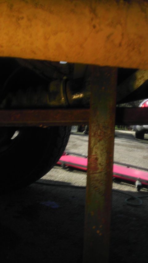 1989 Ford Bronco - Close-up of vehicle undercarriage, focusing on suspension and tire components.