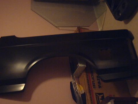 1990 Ford Bronco - A black fender panel, likely for a truck or SUV, is shown against a wall.
