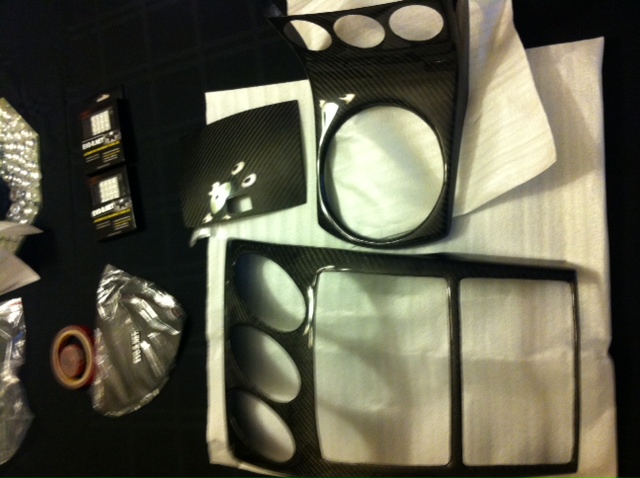 Carbon fiber interior trim pieces with three circular cutouts and a rectangular cutout
