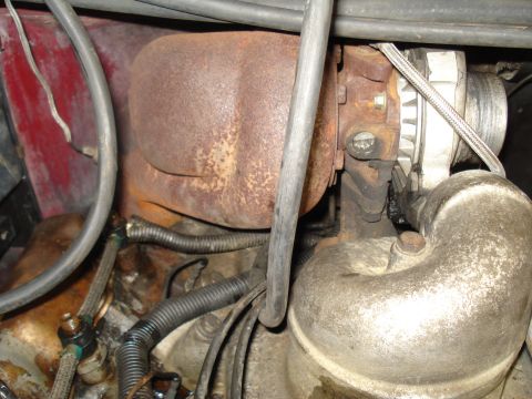 1989 Ford F-250 - This image shows a close-up view of engine components, including a turbocharger and alternator, with visible rust and grime.
