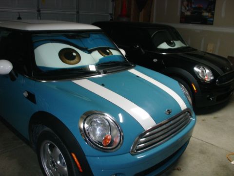2010 MINI Cooper - Two MINI Coopers are parked in a garage, each with custom sunshades designed to look like cartoon eyes.